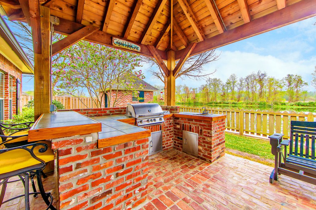 Outdoor brick kitchen patio with grill under pavilion